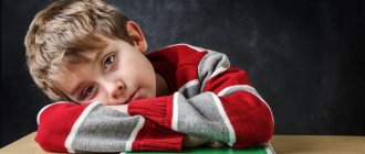 A tired boy lies on his desk